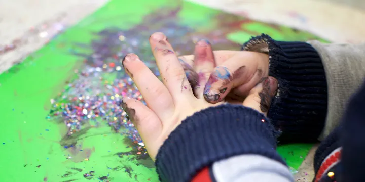 Cocoon Childcare Child painting with glitter