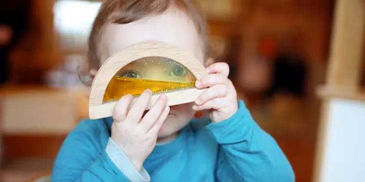 Cocoon Childcare Toddler looking through toy