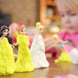 Cocoon Childcare - Girl playing with Barbie and Playdoh