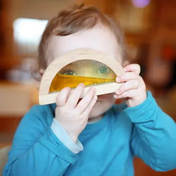 Cocoon Childcare Toddler looking through toy